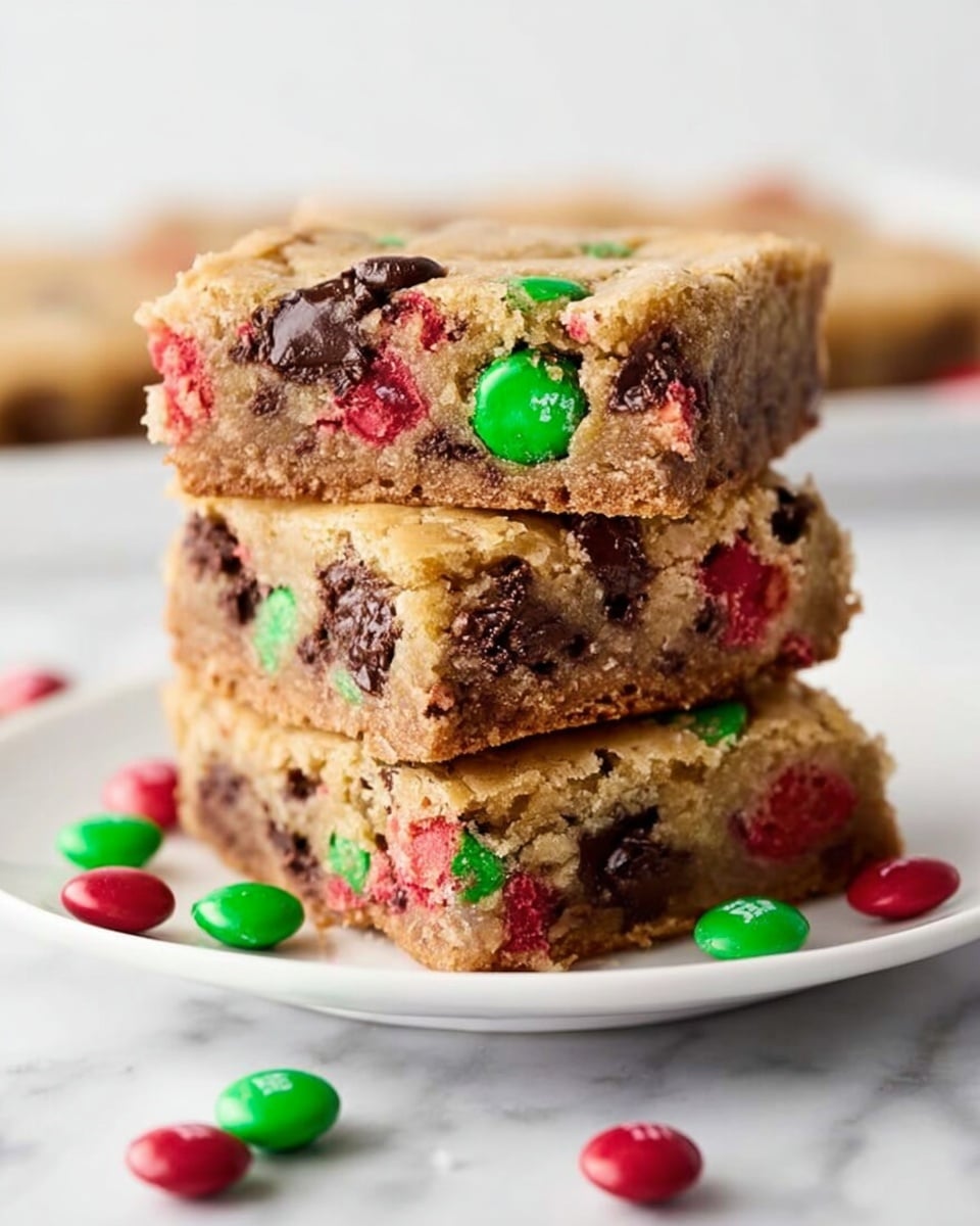 A stack of four thick brownie bars sits on a white plate against a white marbled surface. Each bar is golden brown with a slightly soft texture, filled with colorful red and green candy pieces scattered throughout, and dark brown chocolate chunks embedded inside. Some extra red and green candies are scattered around the plate, adding bright spots of color. The bars have a slightly rough top and edges, showing a chewy, dense inside. photo taken with an iphone --ar 4:5 --v 7