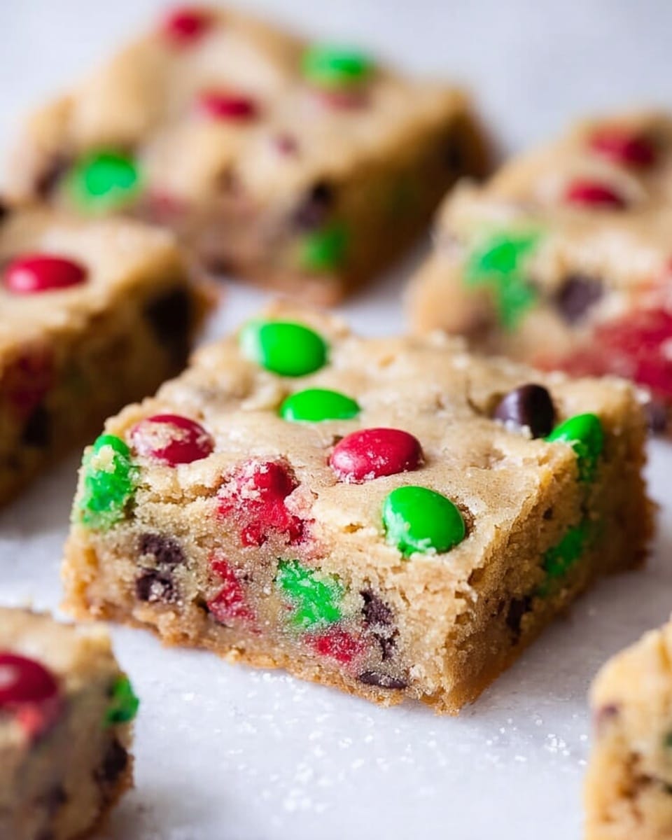 The image shows several square blondie bars with a light golden brown color and a slightly crumbly texture. Each blondie is studded with bright red and green candy pieces and dark chocolate chips, evenly spread throughout the surface and inside. They are placed close to each other on a white marbled textured surface. The focus is on the square blondie in the center, showing clear details of the colorful candies and the soft, thick texture. photo taken with an iphone --ar 4:5 --v 7